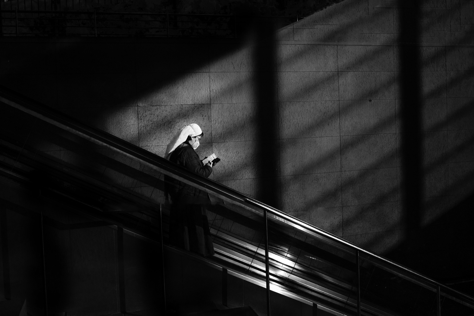 Nonne auf Rolltreppe