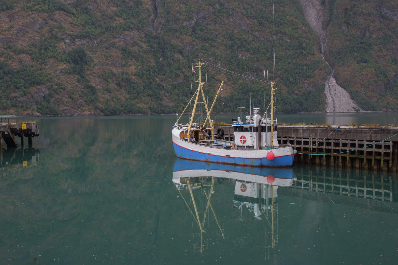 norwegisches Fischerboot gespiegelt im Fjord