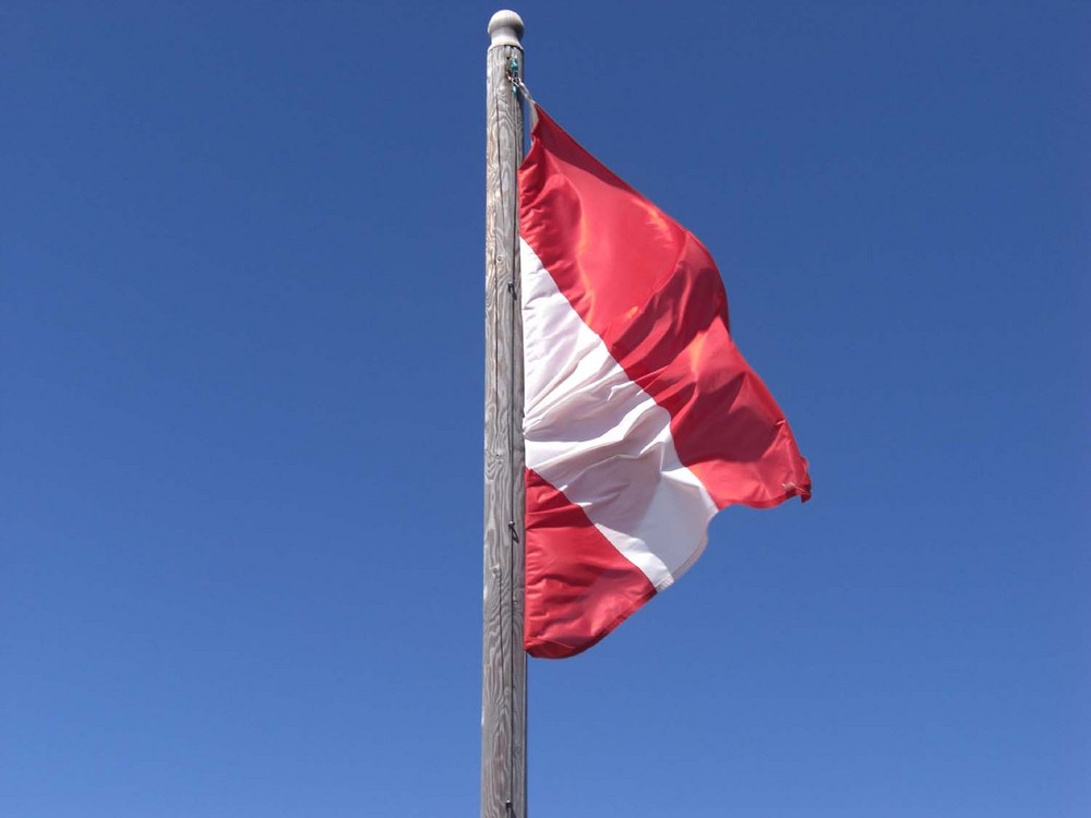 Österreichs Flagge vor blauem Himmel