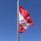 Österreichs Flagge vor blauem Himmel