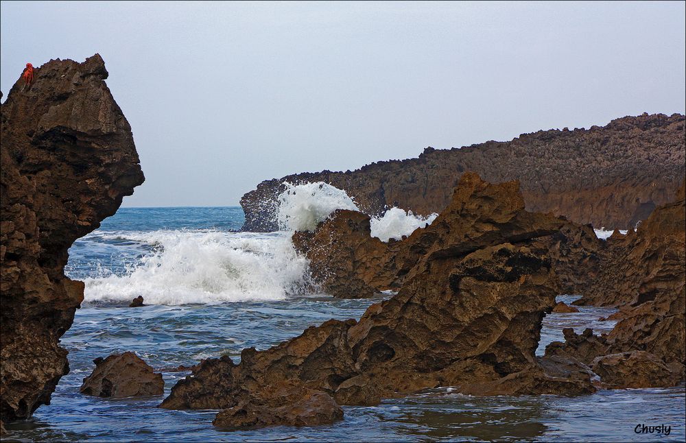 Ola rompiendo contra las rocas