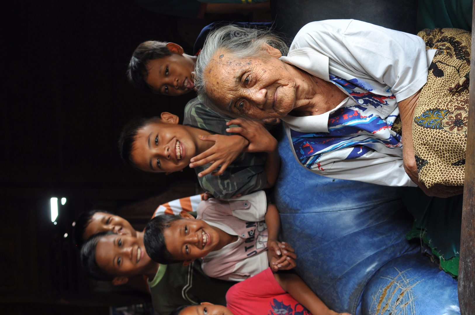 Old indonesian Lady surrounded by Kids