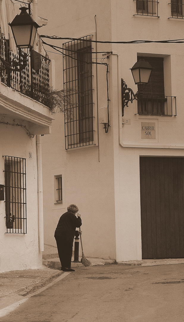 Old woman is cleaning a curbstone, Altea, Spain