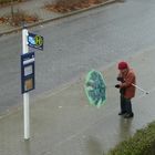 Oma im Sturm mit Stock und aufgeklapptem Schirm in zu großen Schuhen