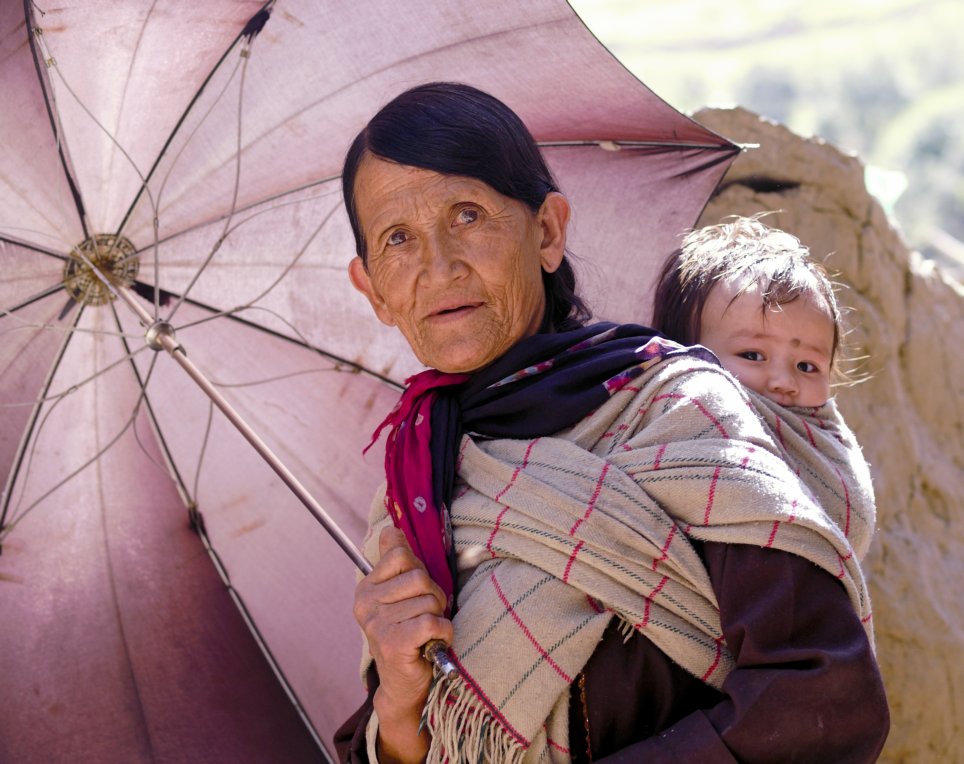 Oma mit Kind unter Regenschirm