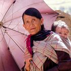 Oma mit Kind unter Regenschirm