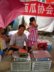 Organisierter Wassermelonenverkäufer und Töchterchen