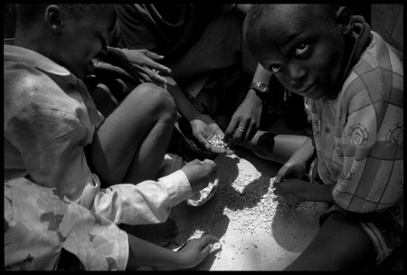 Partage des graines tombées pendant la distribution par les orphelins n'ayant rien reçu