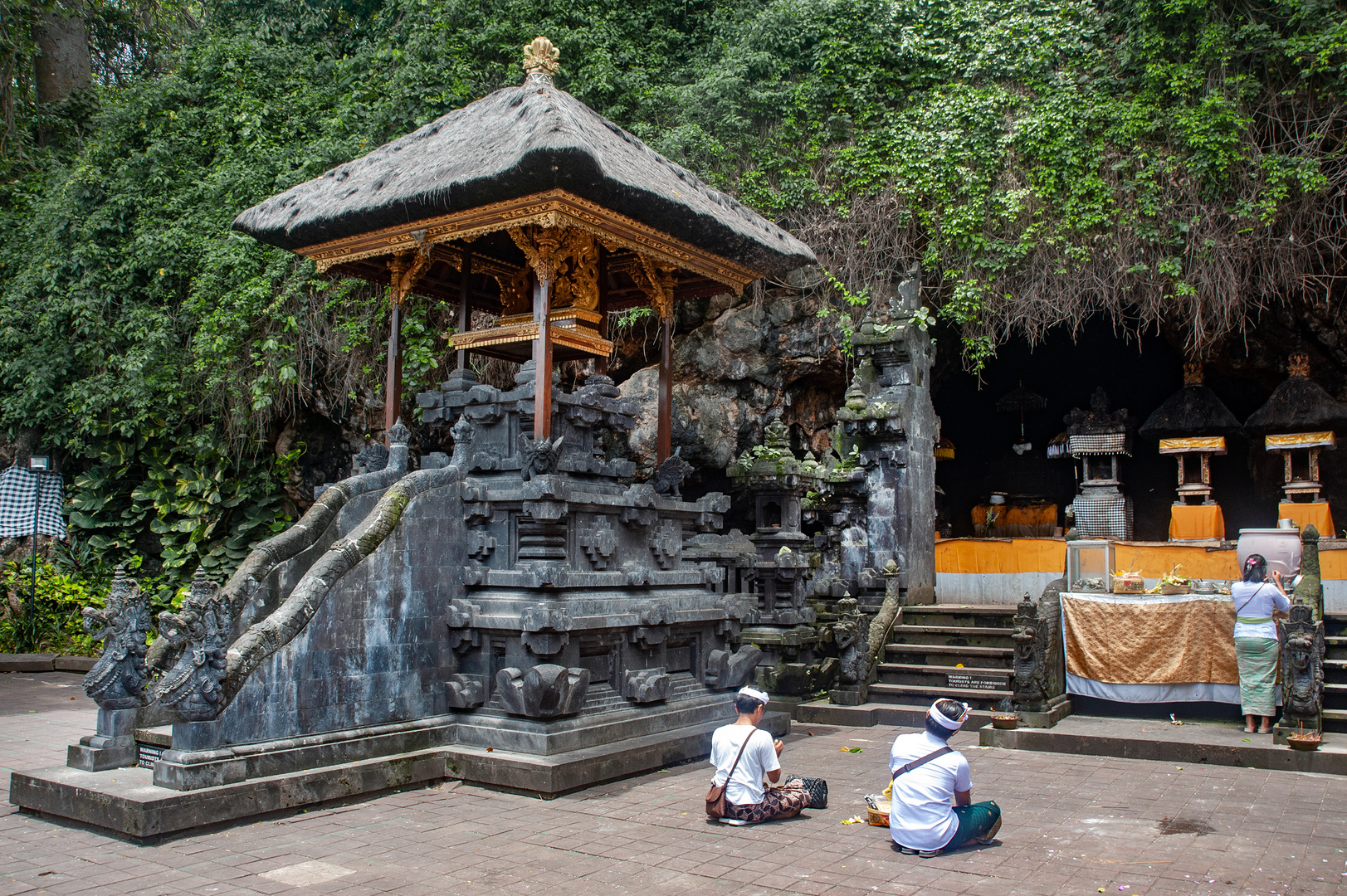 People pray in front of the cave