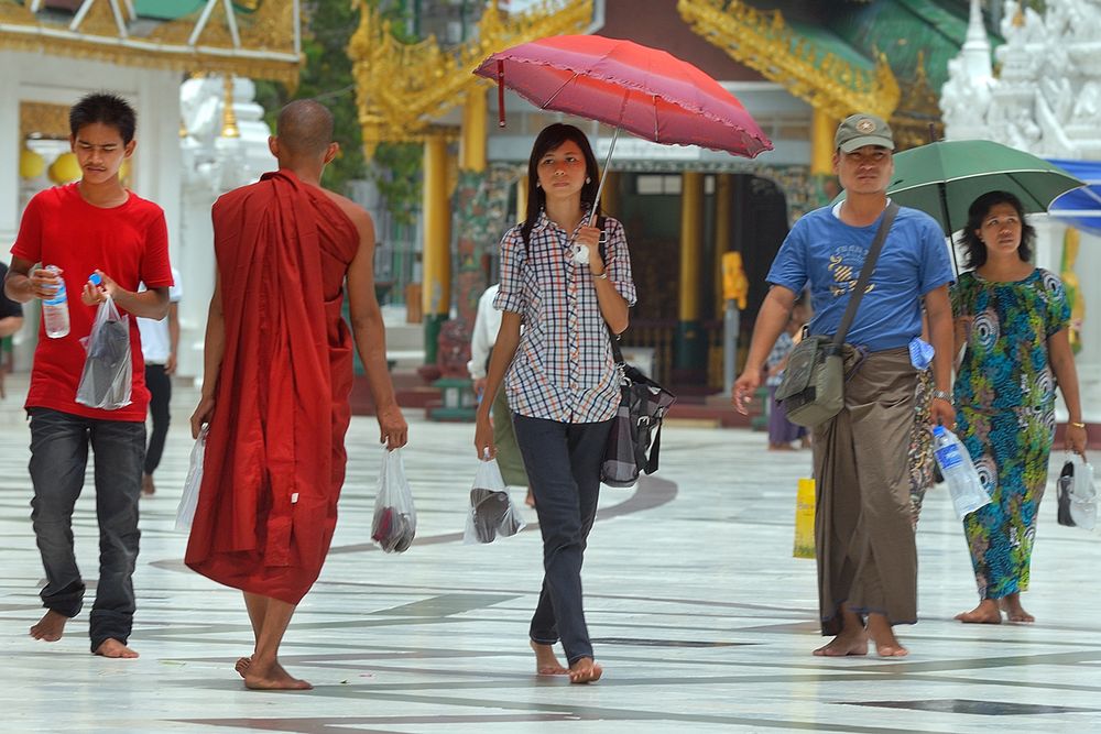 People walk around the Shwedagon pagoda