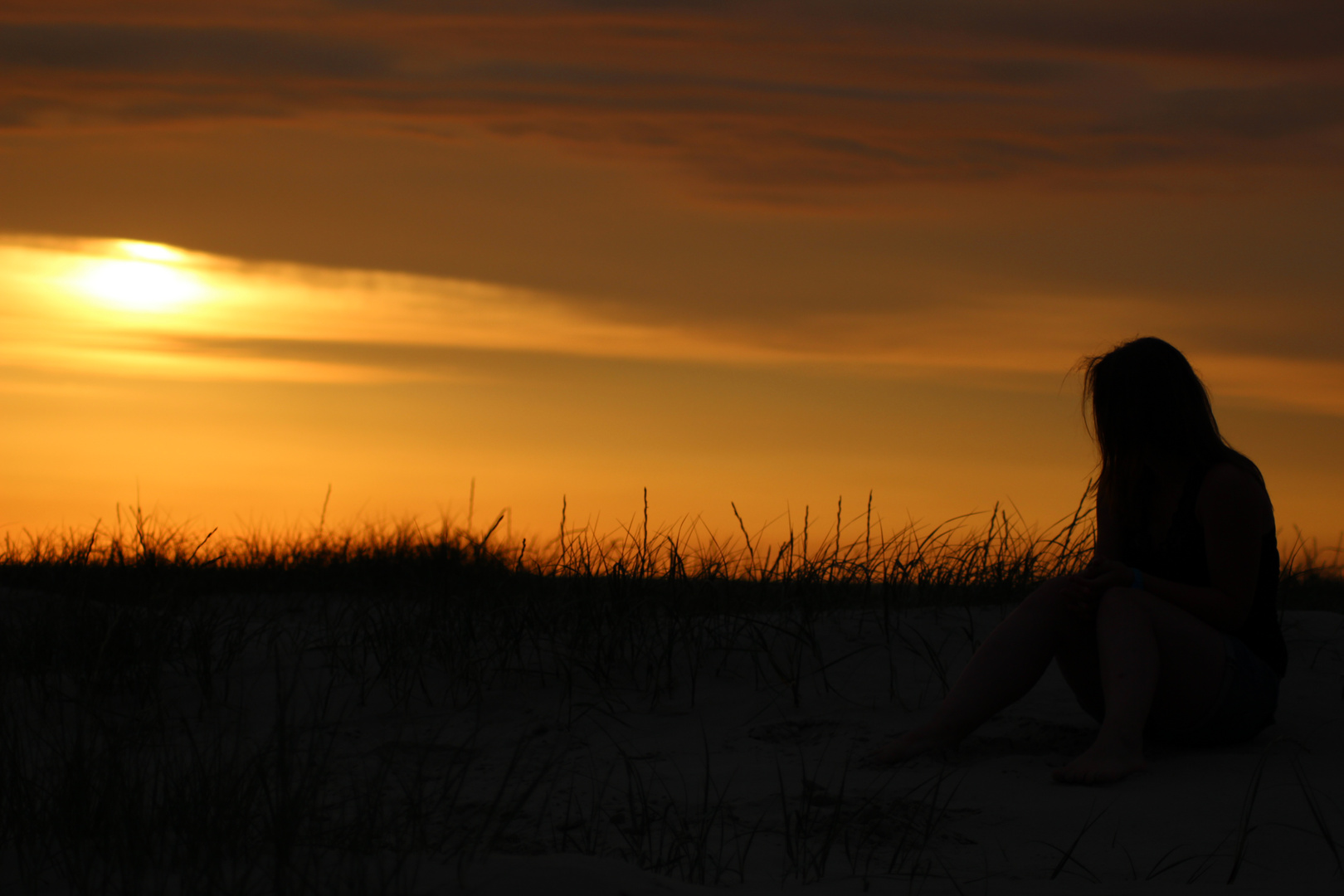 Person am Strand im Sonnenuntergang