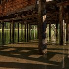 Pfostenspiegelungen und Schattenwürfe unter dem Bootshaus am Pragser Wildsee.