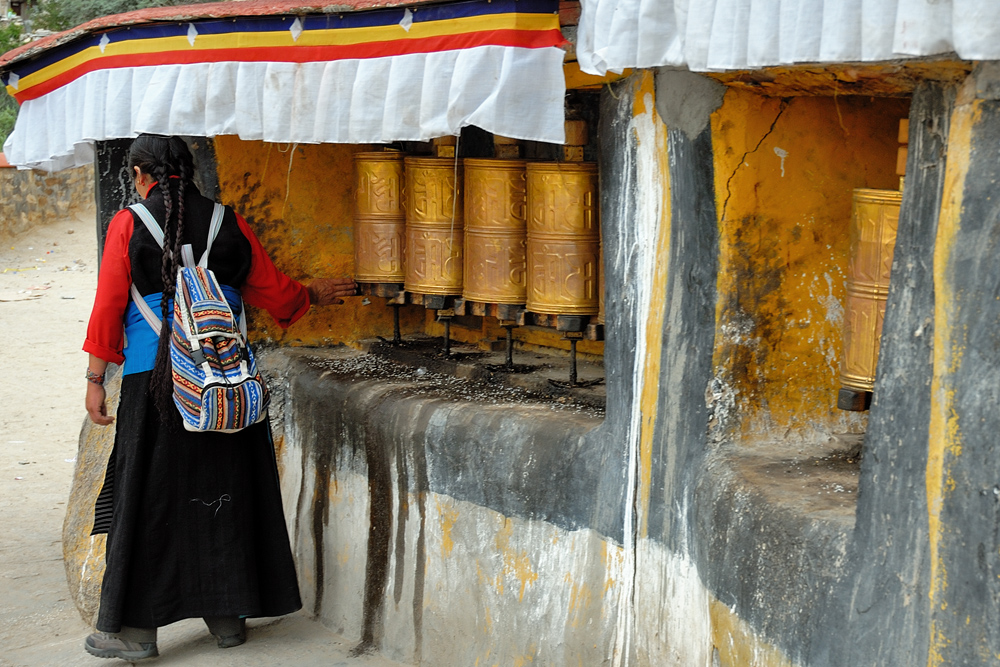 Pilgrim woman turning prayer wheels