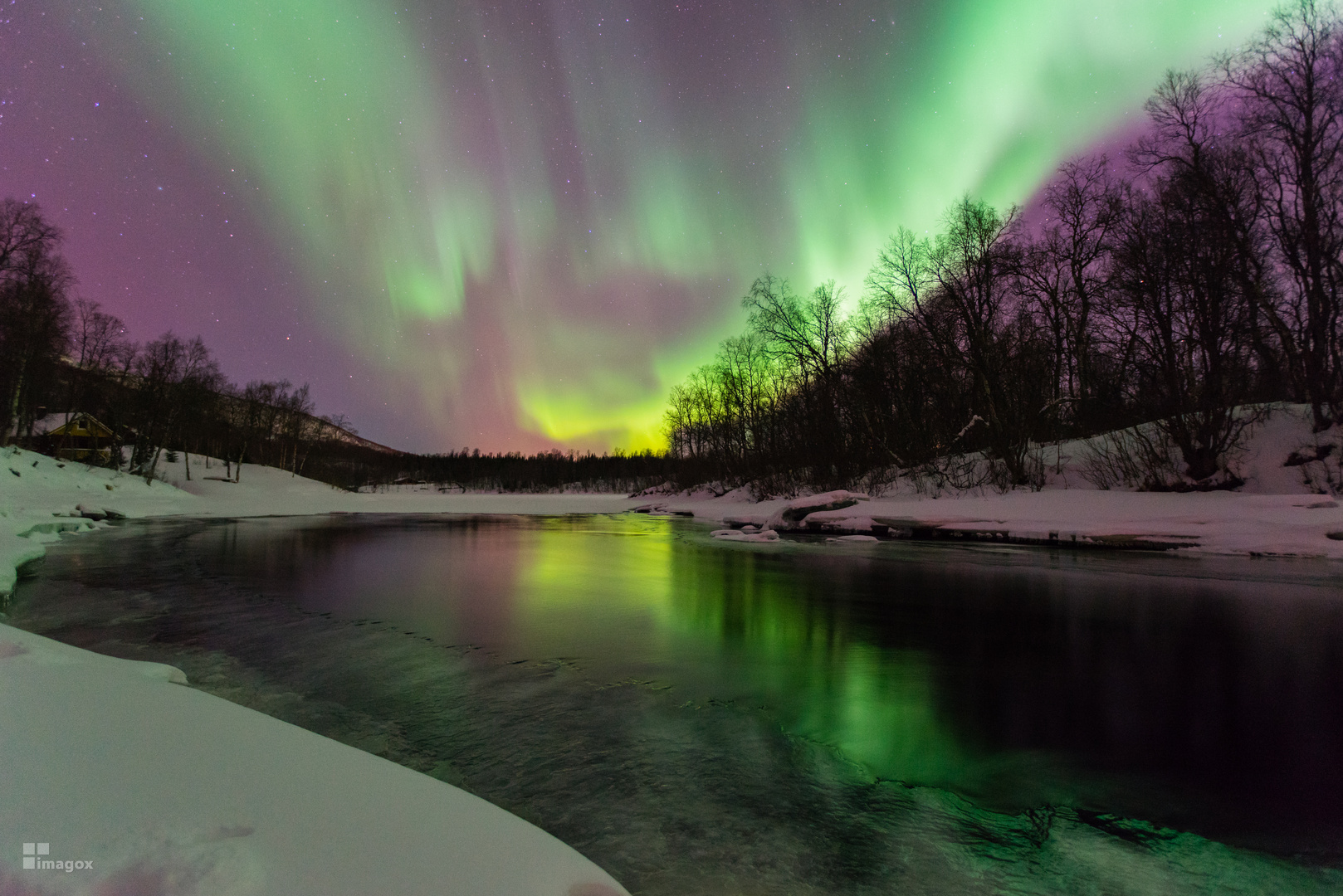 Polarlicht über einem vereisten Fluss bei Finnsnes