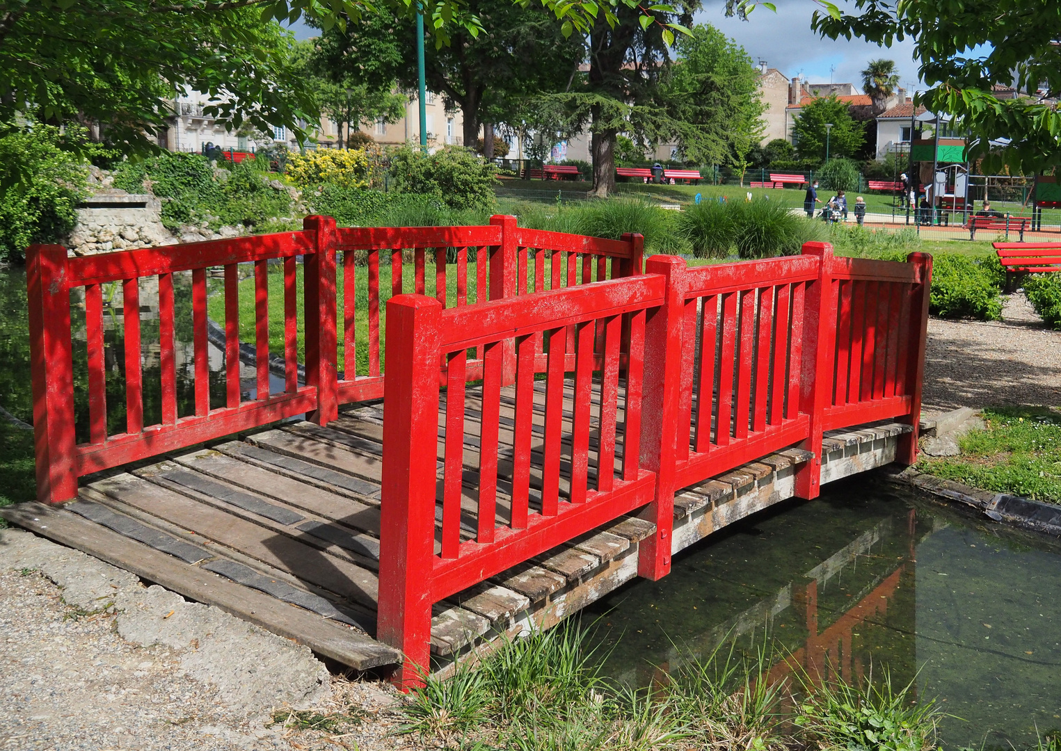 Pont et bancs rouges au Jardin Jayan à Agen