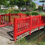 Pont et bancs rouges au Jardin Jayan à Agen