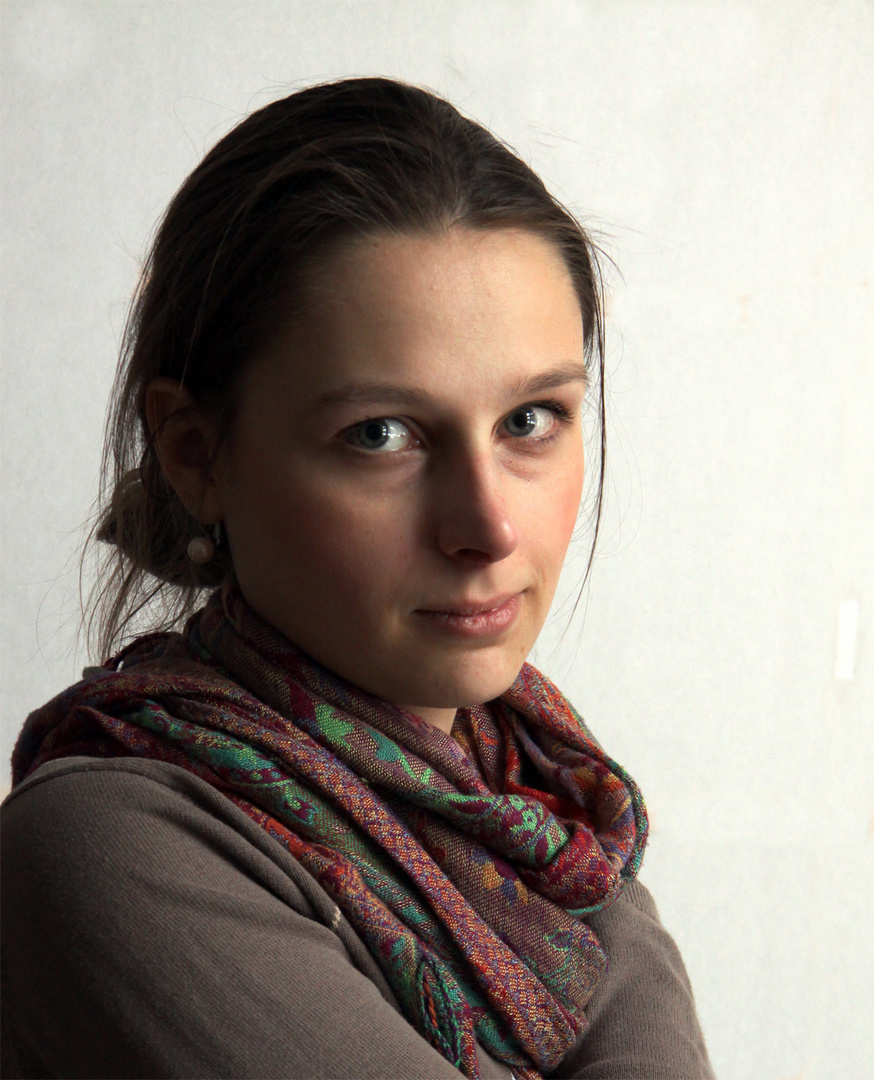 Portrait einer jungen Frau mit Perlenohrring am Fenster