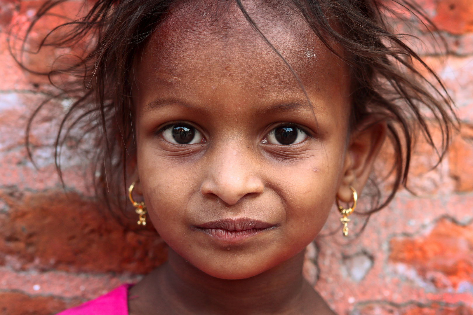 Portrait of a girl on the background of shaggy old brick wall