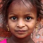 Portrait of a girl on the background of shaggy old brick wall