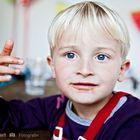 Portrait von blondem Jungen mit Tomatensoße