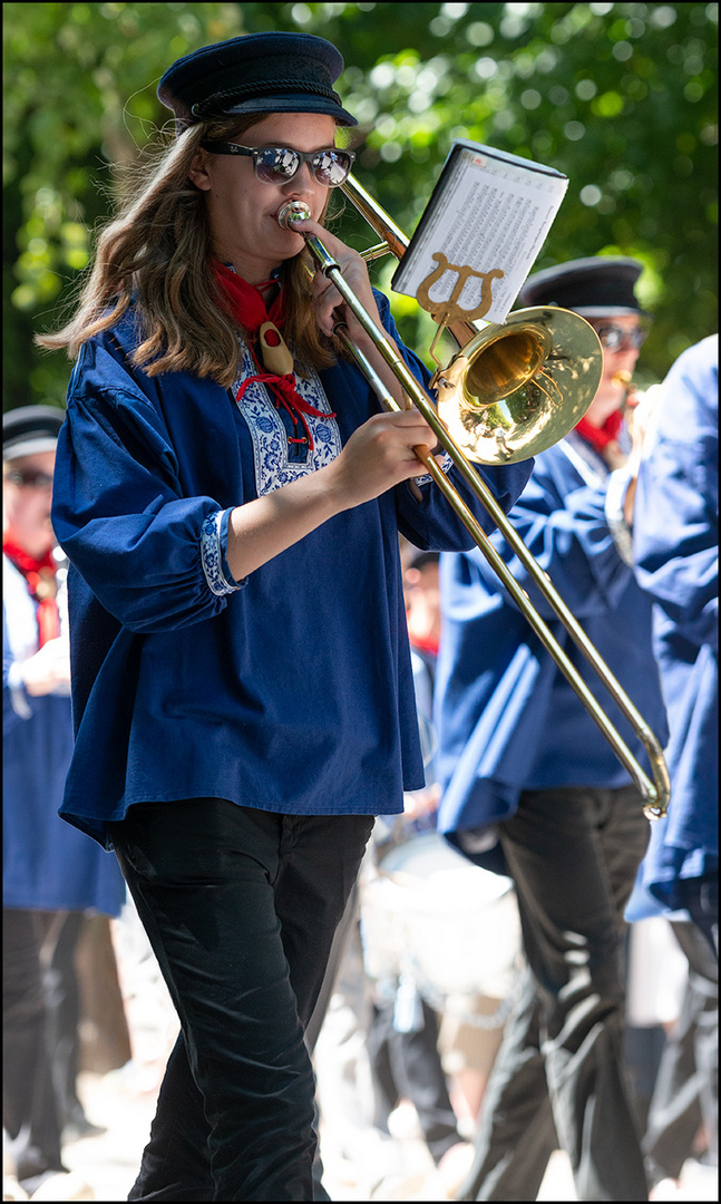 Posaunistin in einer Musikgruppe auf einem Festzug