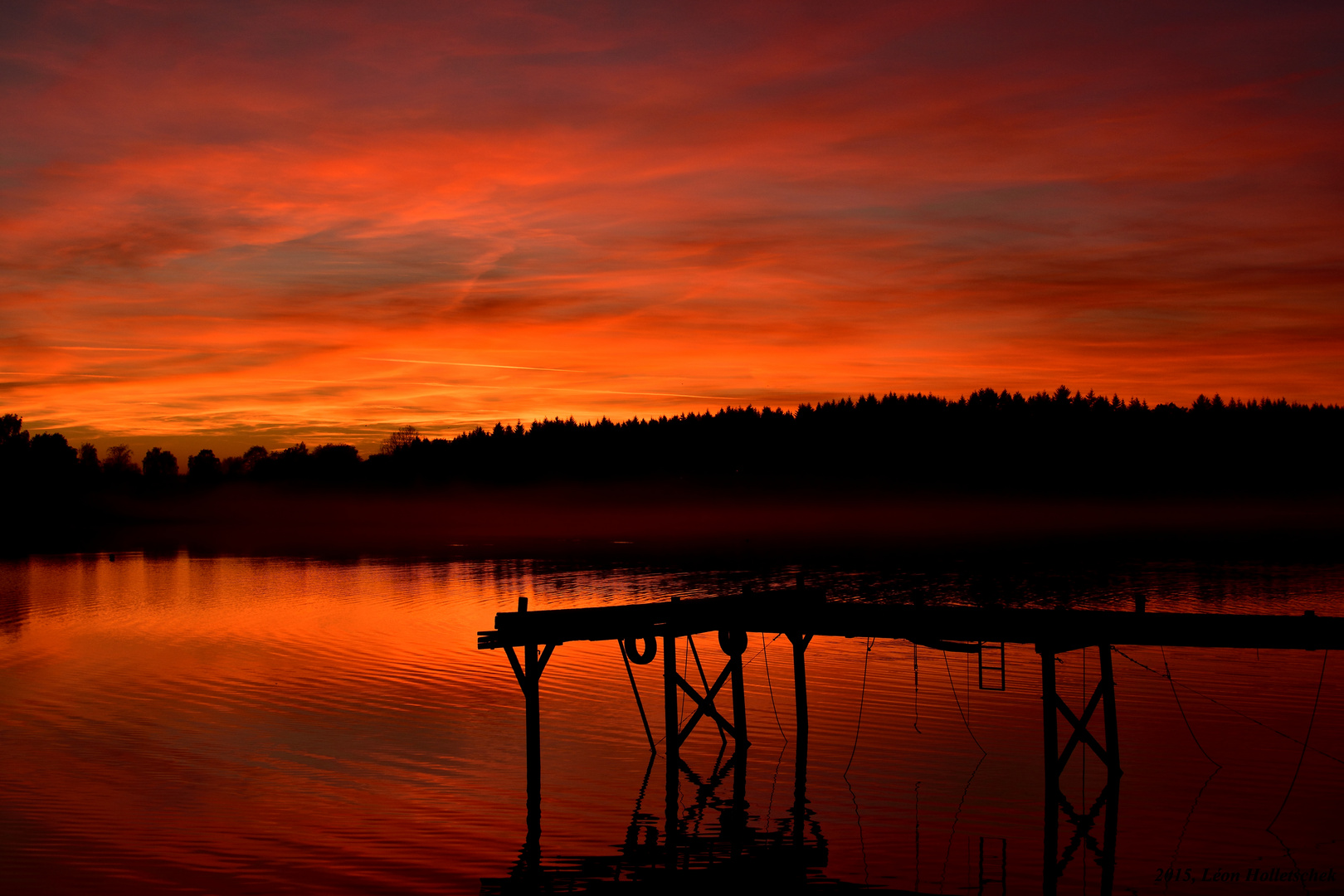 Purpur roter Sonnenuntergang über heimischem See