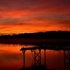 Purpur roter Sonnenuntergang über heimischem See