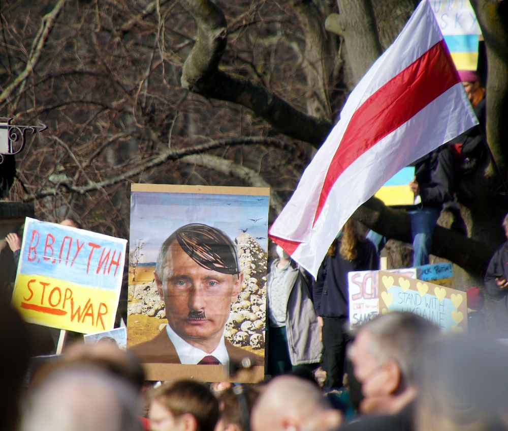 Putler neben der Widerstandsfahne von Belarus