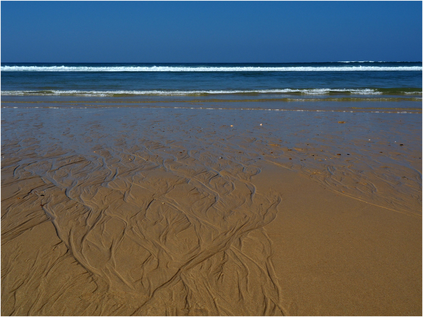 Quand la mer dessine sur le sable