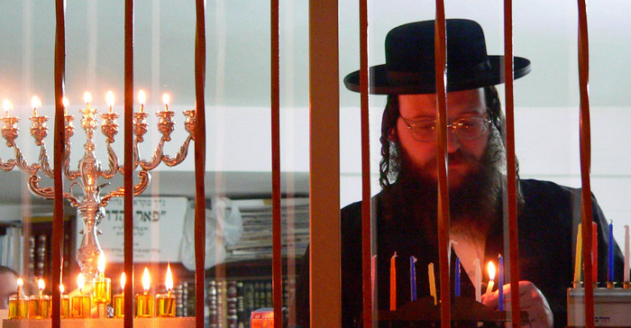 Rabbi zuendet die Chanuka Lichter...