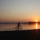 Radfahrer im Chiemsee bei Sonnenuntergang