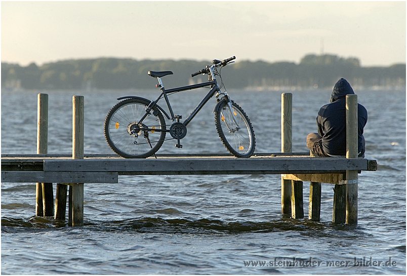 Radfahrer mit Fahrrad auf einem Steg auf dem Steinhuder Meer