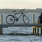 Radfahrer mit Fahrrad auf einem Steg auf dem Steinhuder Meer