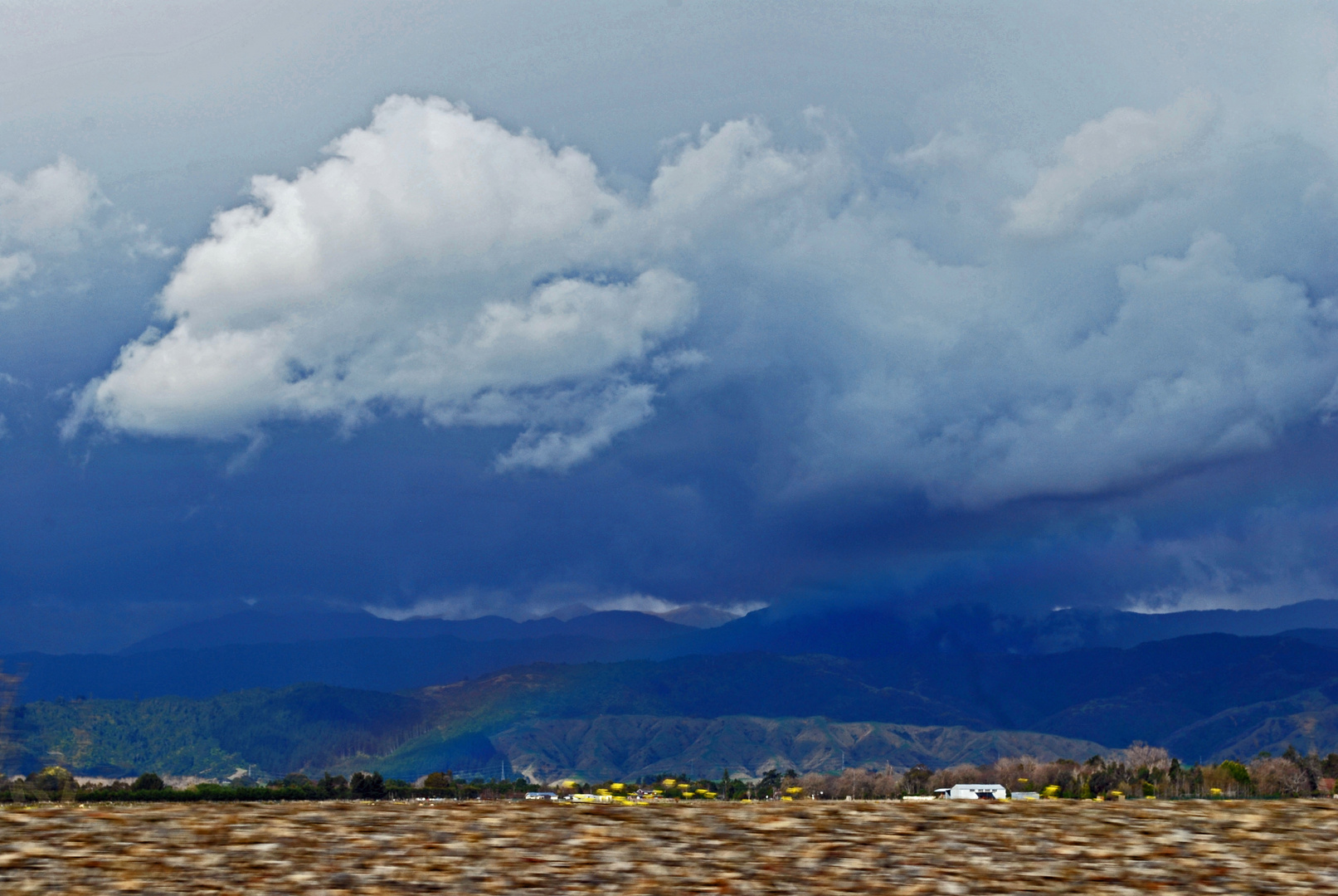 Rainbow under heavy rain clouds