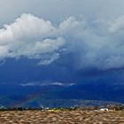 Rainbow under heavy rain clouds