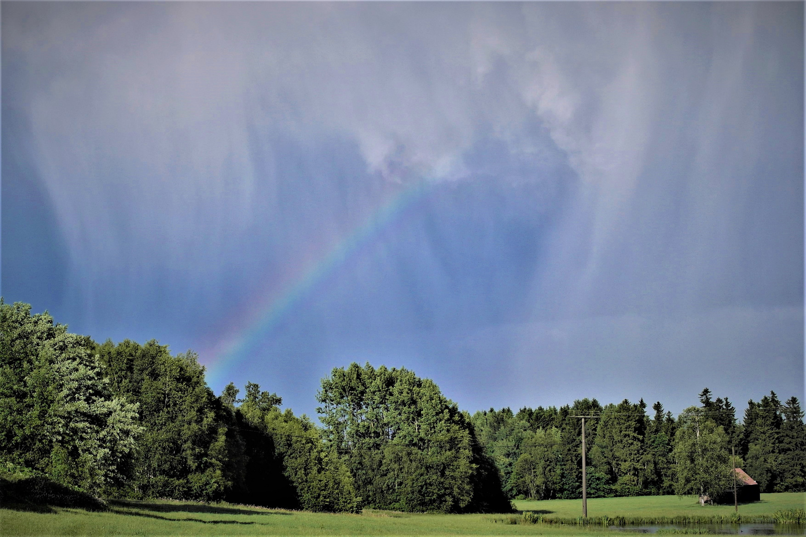 Regenbogen kommt durch Regenwand 