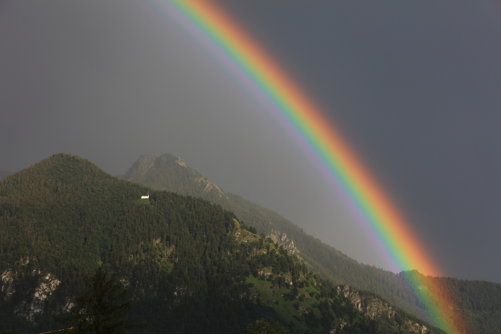 Regenbogen über den Chiemgauer Bergen