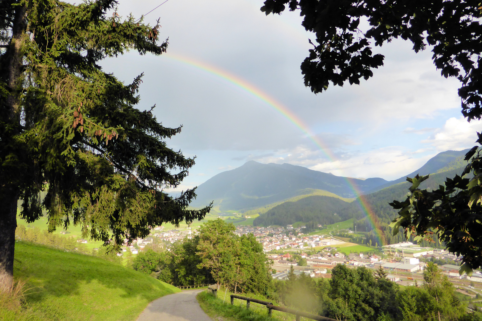 Regenbogen über den Hügeln einer anmutigen Landschaft