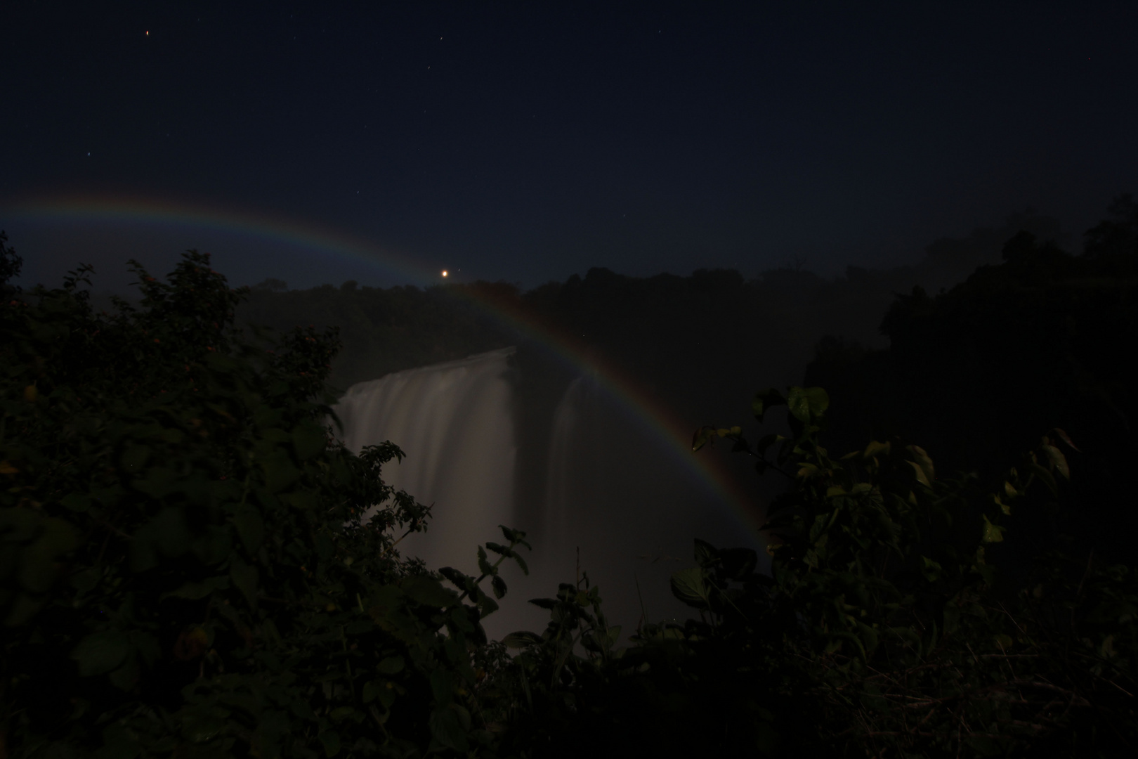 Regenbogen über den Victoriafällen nachts bei Vollmond