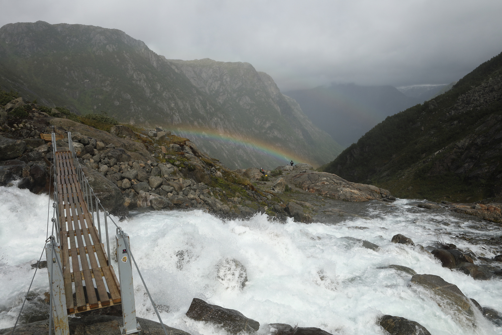 Regenbogen über reißendem Fluss