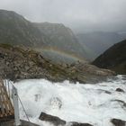 Regenbogen über reißendem Fluss