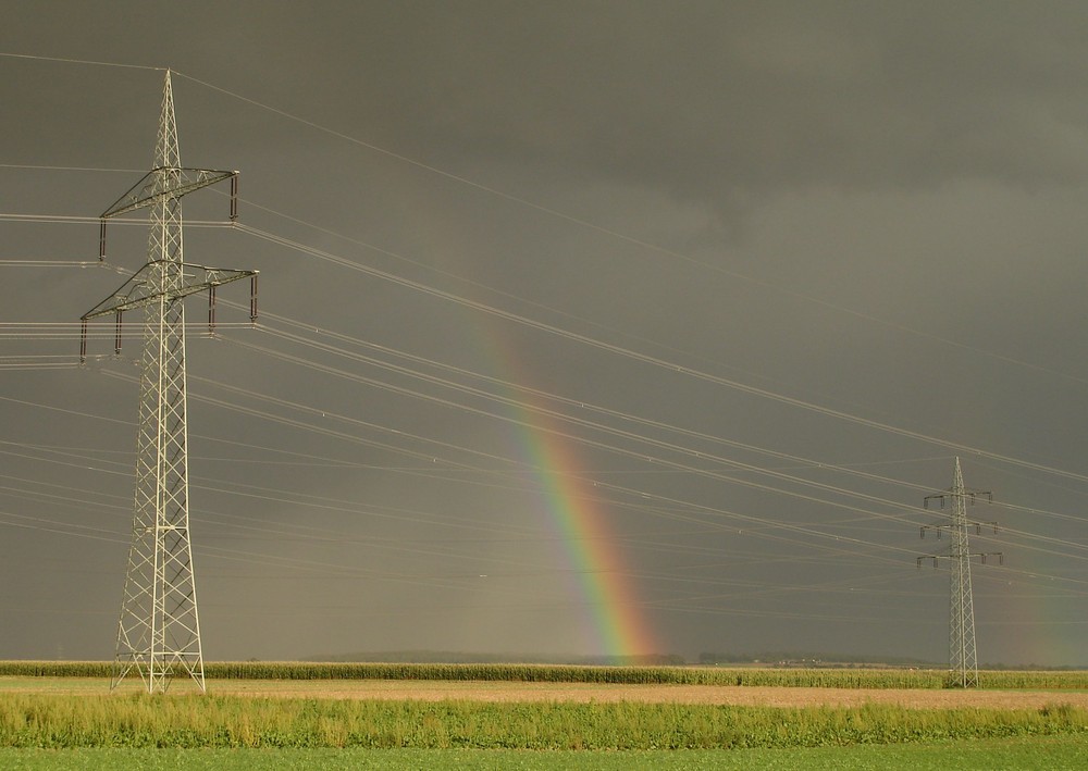 Regenbogen zwischen Strommasten