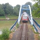 Regionalbahn auf Brücke über Kanal