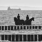 Reiterinnen in der Ostsee mit Buhnen und Schiff