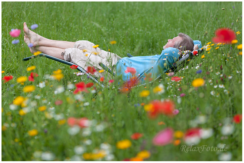 "RelaxFoto von RelaxFoto" Mann liegt entspannt in Wildblumenwiese