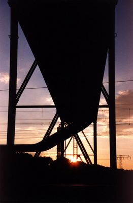 Rohrbrücke über Schienen beim Sonnenuntergang