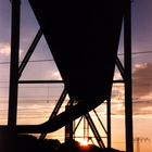 Rohrbrücke über Schienen beim Sonnenuntergang