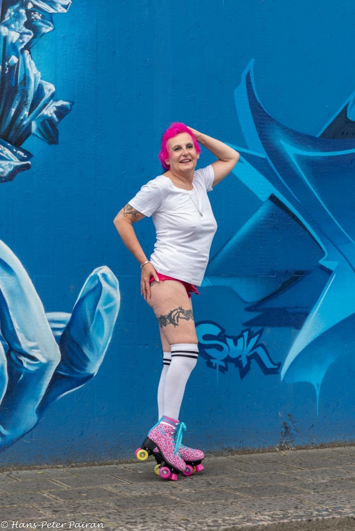 Rollergirl vor Graffiti Wand