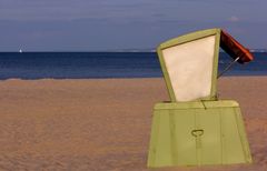 Roofed wicker beach chair before sunset