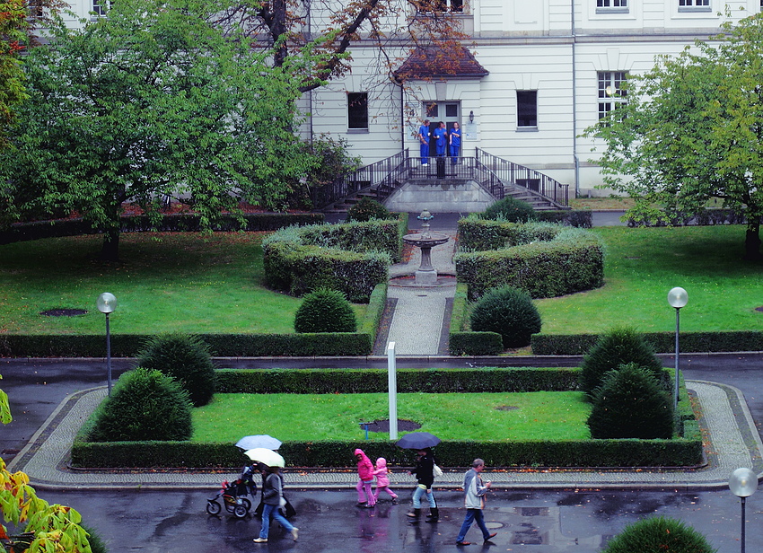 Rosa Kinder und blaue Pfleger im Regen